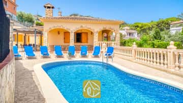 Privater Swimmingpool im Freien mit leuchtend blauem Wasser, umgeben von Sonnenliegen und einer Steinterrasse in der Villa Sarai in Spanien.