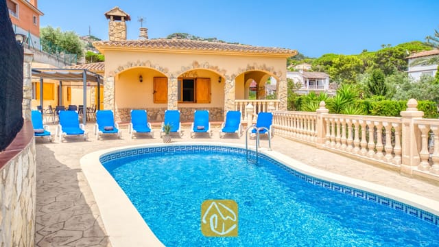 Privater Swimmingpool im Freien mit leuchtend blauem Wasser, umgeben von Sonnenliegen und einer Steinterrasse in der Villa Sarai in Spanien.