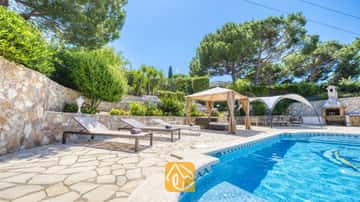 Privater Pool mit Sonnenliegen und Steinterrasse in der Villa Lorena, umgeben von Pinien, terrassierten Gärten und einem schattigen Pavillon.