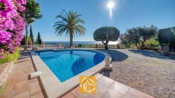 Privater Pool in der Villa Gabriella mit Meerblick, einer Palme und einer steinernen Buddha-Statue auf der gefliesten Terrasse.