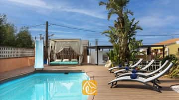 Privater Pool mit blauer Rutsche, Holzdachterrasse, grauen Sonnenliegen mit blauen Handtüchern und einer Vorhang-Cabana in der Villa Soleia.